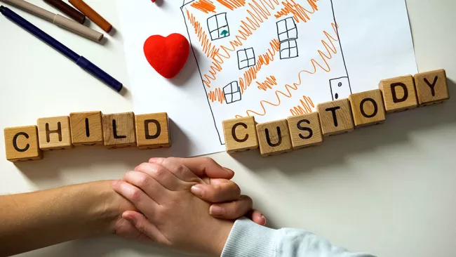 Child custody photo with school blocks and child's hand.